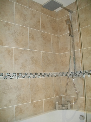 The bathroom has a contemporary over-bath shower