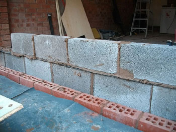 The double skin new wall has concrete blocks inside and a red brick exterior