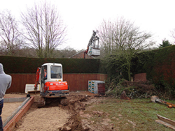 More building materials arrive -cleverly hoisted over the hedge!